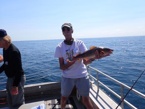 man on boat holding a cod